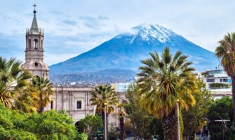 The skyline of Arequipa, Peru with a historic church in the foreground and a volcano in the background