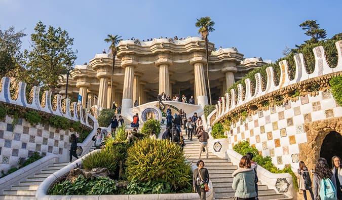 People walking up the stairs near stunning Gaudi architecture in beautiful Barcelona, Spain on a sunny summer day