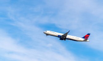 A Delta airplane climbing intoa bright blue sky after takeoff in the USA