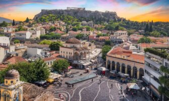 Cityscape of Athens at sunset with the historic center in the foreground and the Acropolis on a hill looming in the background