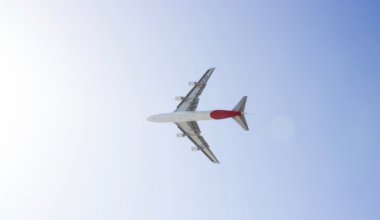 A lone aircraft flying through the blue sky