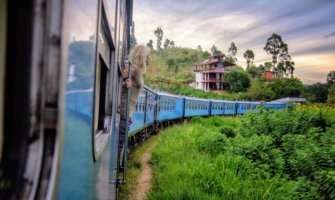 A woman on a train traveling around lush Sri Lanka