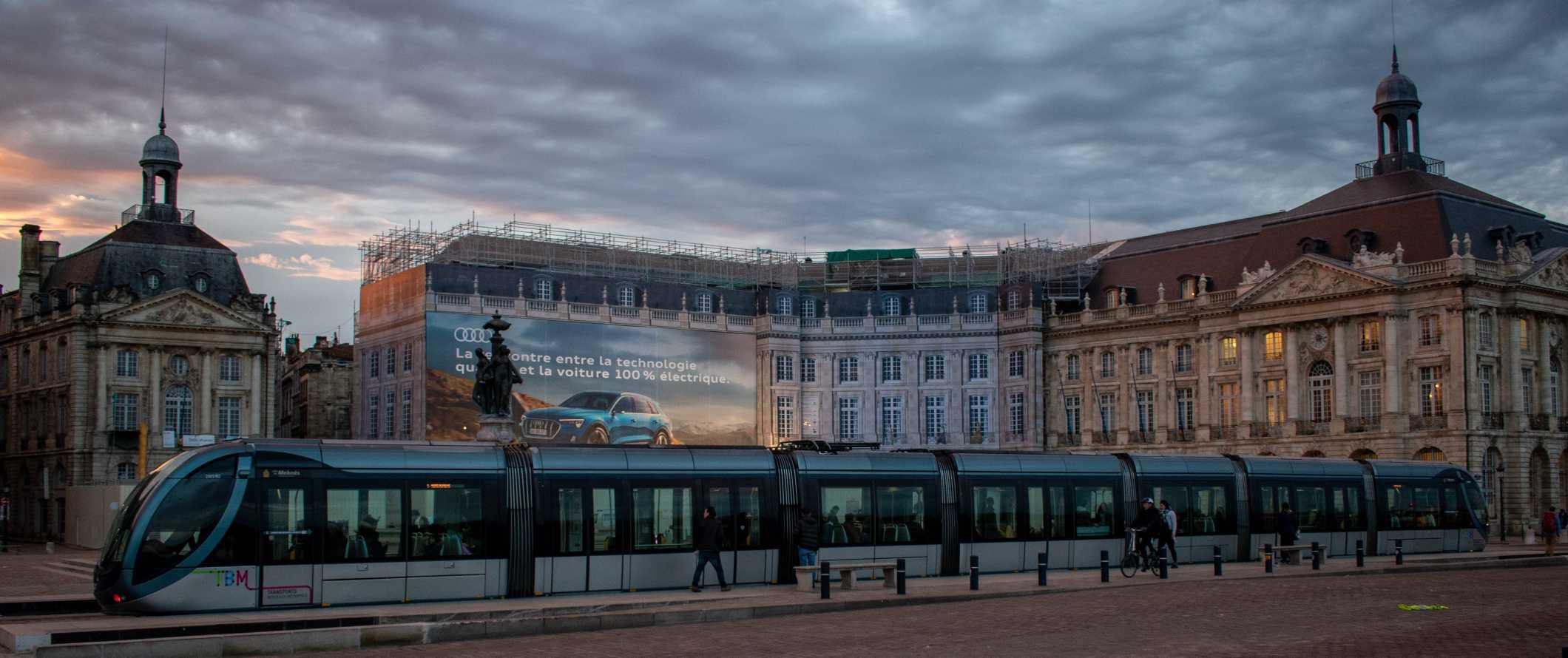 People boarding a tram at sunset in the Old Town of Bordeaux, France