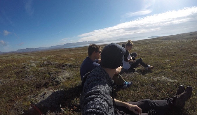 A group of travelers on a road trip having lunch in the grass