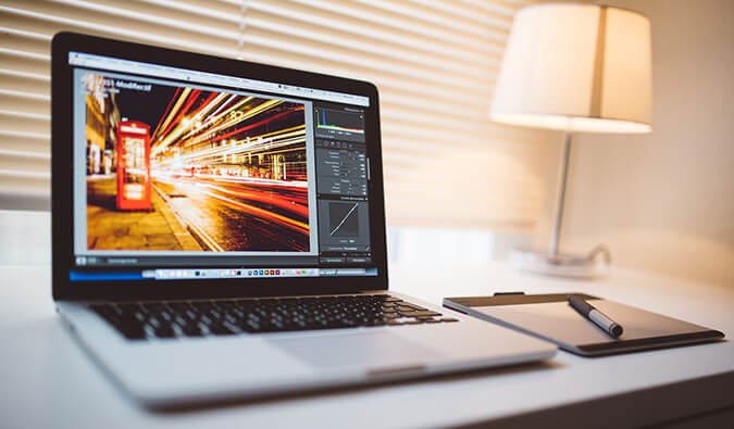 laptop on a table showing a image being edited