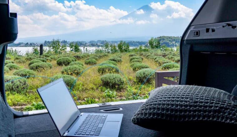 A laptop in a van as a digital nomad admires Mount Fuji in Japan