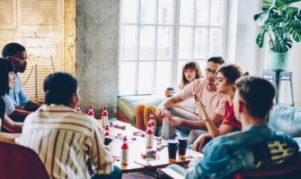 New friends in a hostel playing games and drinking together