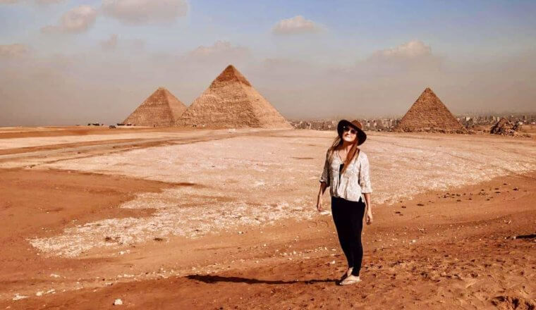 Monica, a solo female traveler, posing near the pyramids in Egypt