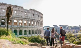 A group of travelers posing near the historic Colosseum in Rome, Italy