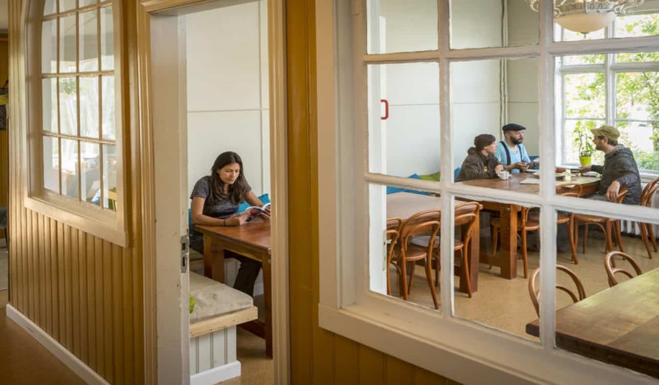 people sitting at long table in Hafaldan hostel common room