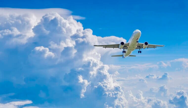 A commercial airplane flying in the bright blue sky