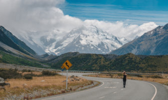 Kristin Addis standing on a empty winding road in the mountains