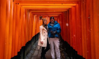 Blogger Kristin Addis of Be My Travel Muse with her partner and baby at Fushimi Inari Shrine in Japan