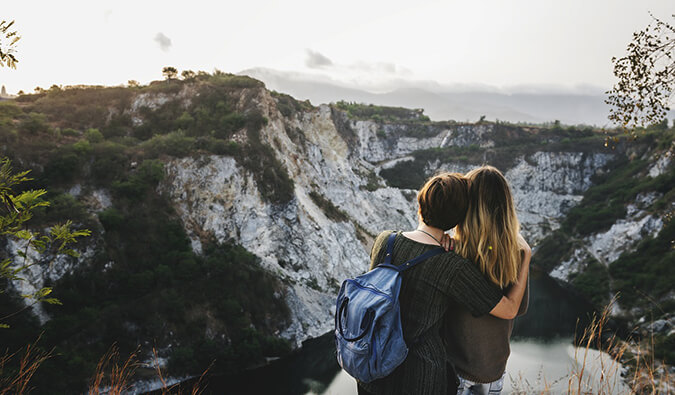 two women hugging looking out over the view of the mountains