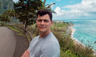 Nomadic Matt posing for a photo along the winding road of Hawaii