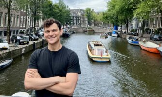 Nomadic Matt posing near the canal in Amsterdam