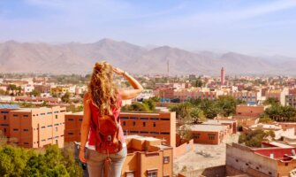 A solo female traveler looking out over a city in Morocco