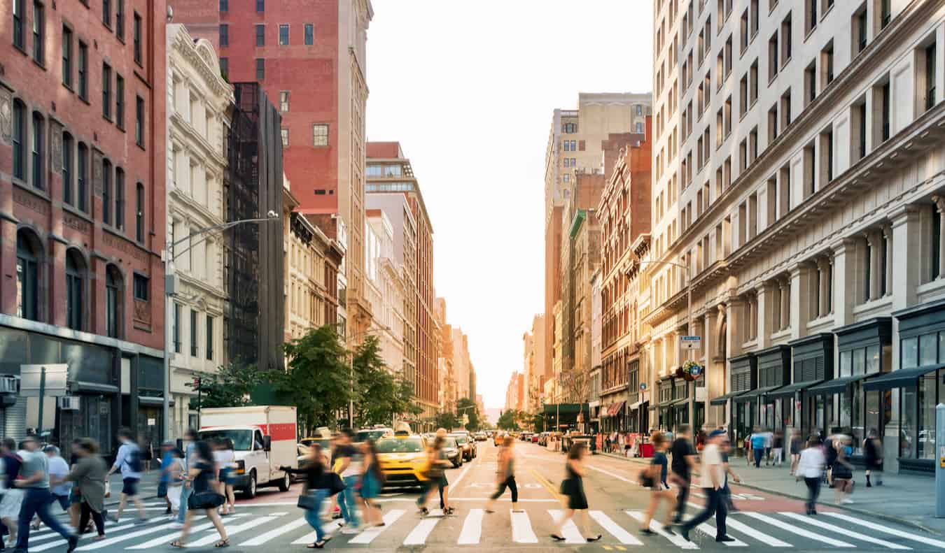 People crossing a busy street in bustling NYC, USA with cars all around