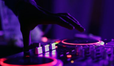 A turntable at a rave with purple lights