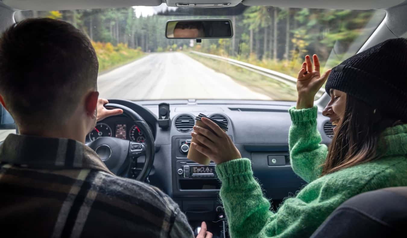 A man and a woman in the front seat of a car