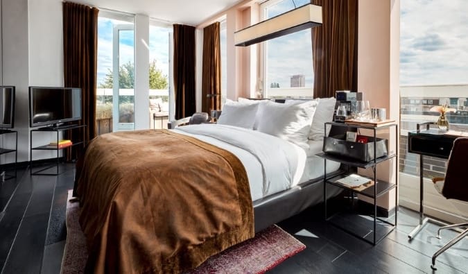 Luxurious guestroom with floor to ceiling windows on two sides at Sir Albert hotel in Amsterdam, the Netherlands