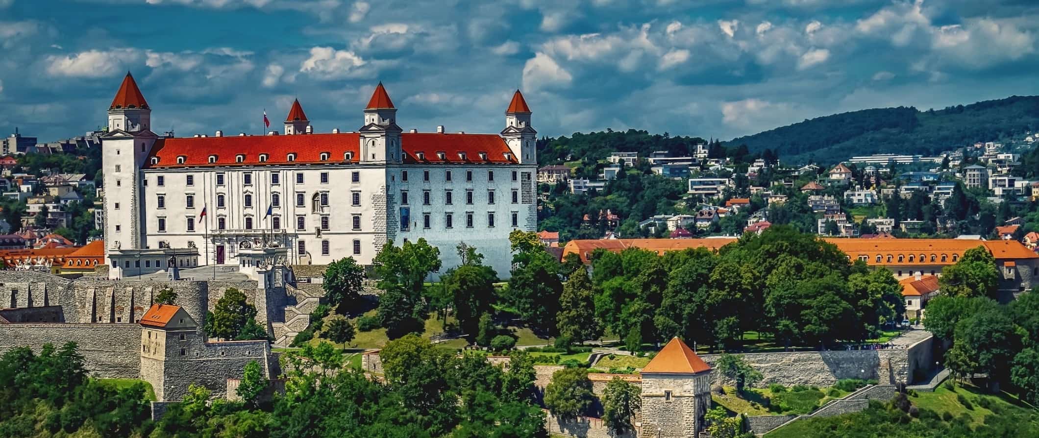 An aerial view of Bratislava, the capital of Slovakia, featuring historic buildings and plenty of greenery