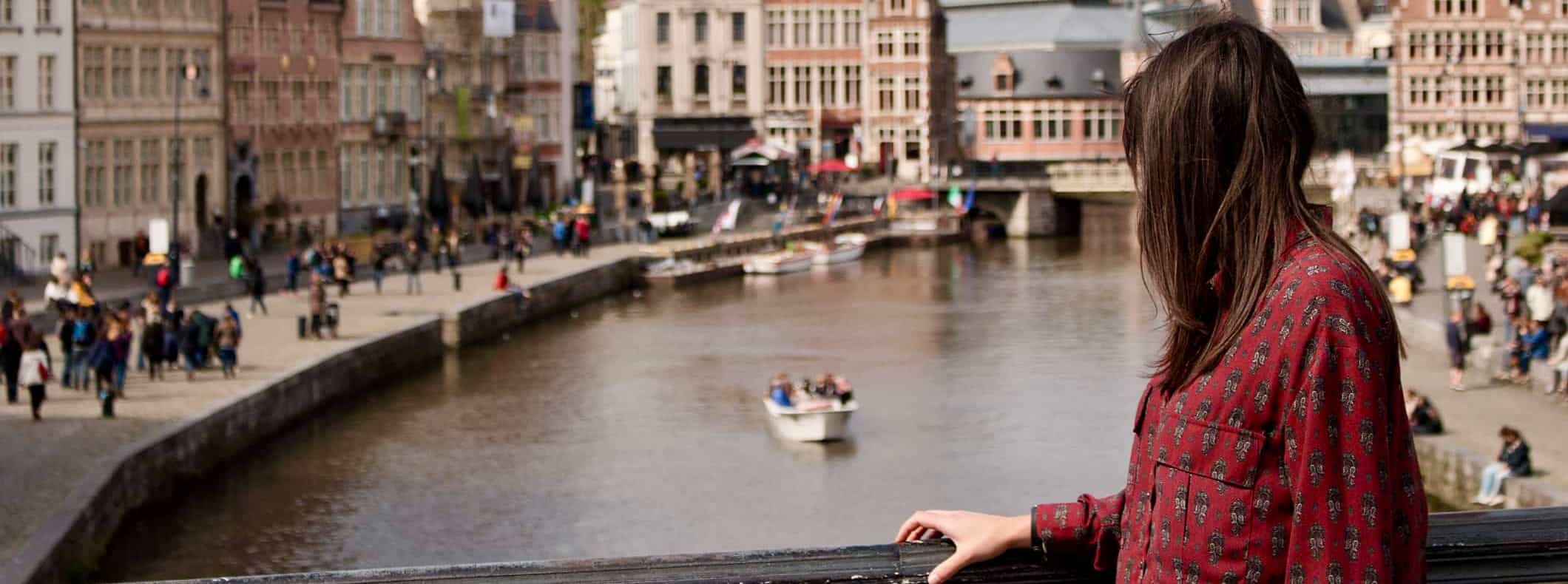 A solo female traveler looking out over a busy cityscape