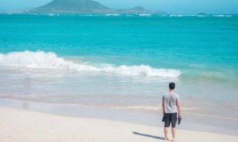 Nomadic Matt alone on a beach in Hawaii