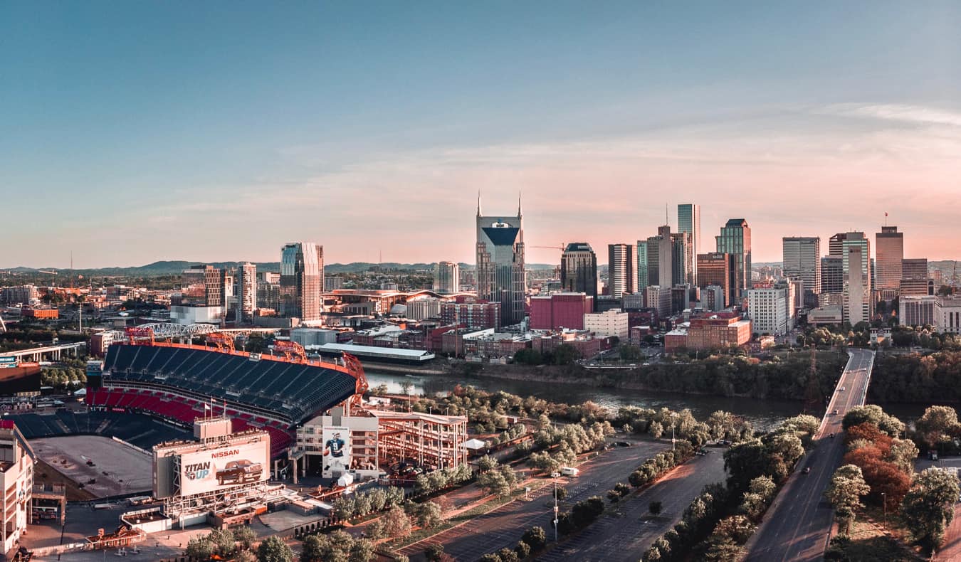 The Nashville stadium and skyline during a soft, pastel sunlight