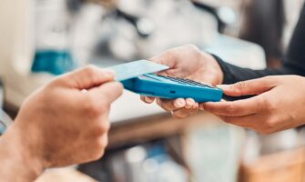 person tapping a credit card to make a purchase