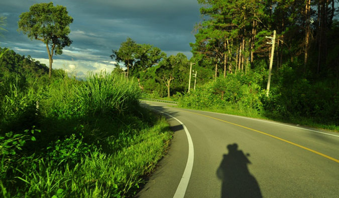 Vikram and Ishwinder from Empty Rusacks riding a motorcycle on an empty paved road